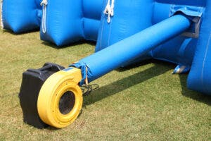 A yellow & black Inflatable blower connected to a blue inflatable unit. 